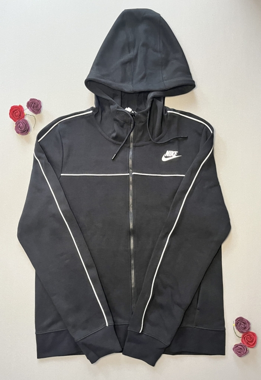 Klasyczna czarna bluza Nike rozpinana na zamek. Wyposażona w kaptur i stylowe białe lampasy. Idealna na trening i na co dzień. Sprawdź dostępność i zamów online!